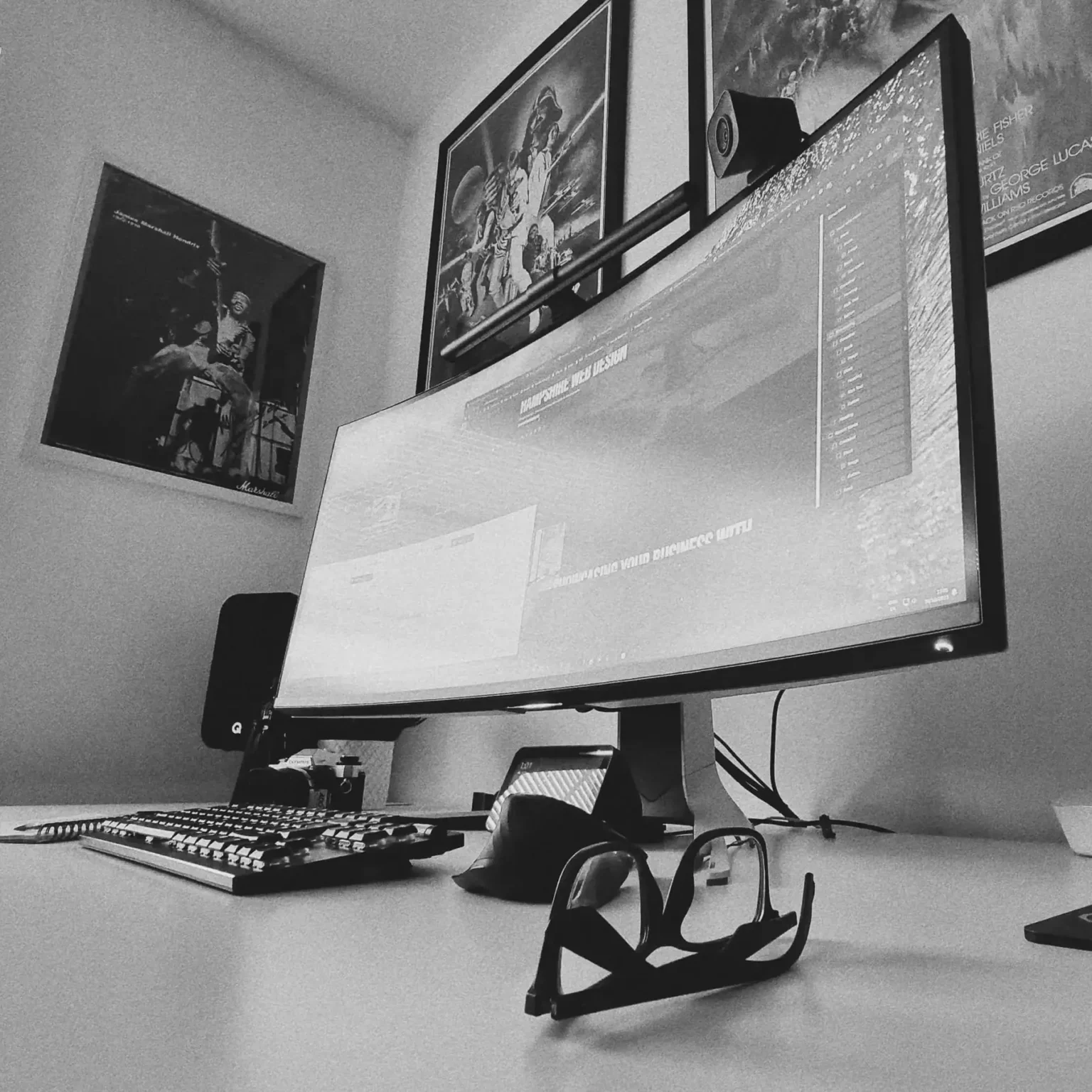 Rod's workspace: a curved monitor, mechanical keyboard and framed prints, in black and white